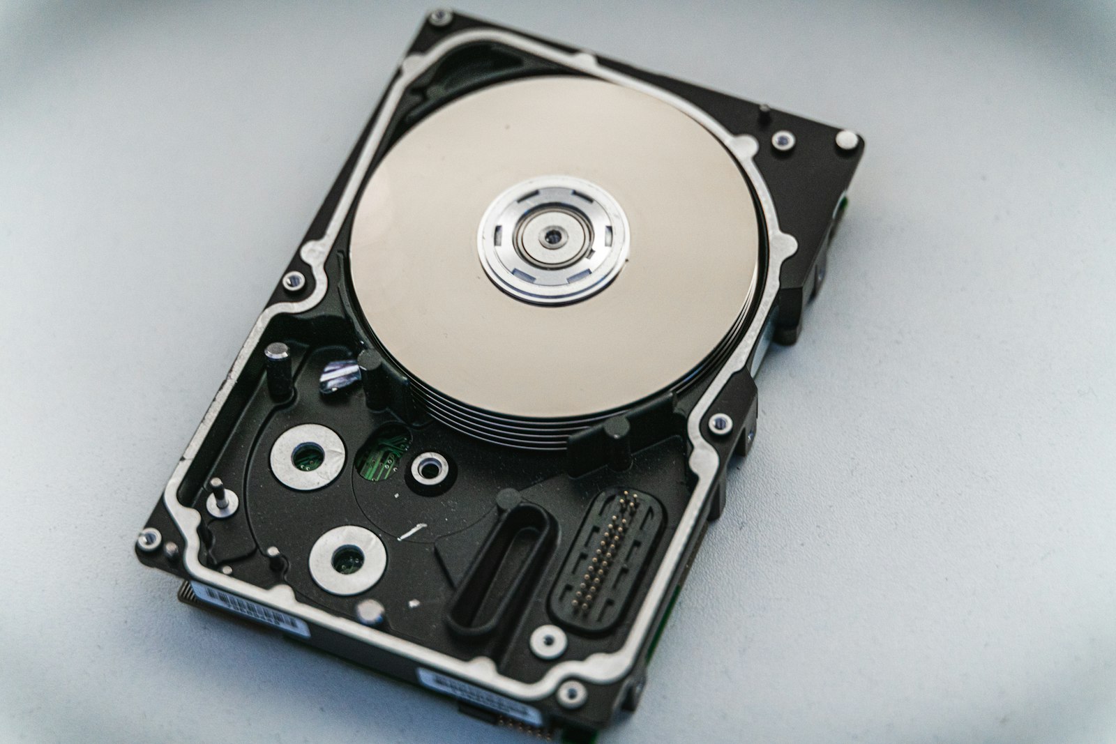 An opened hard drive showing the platter and read head