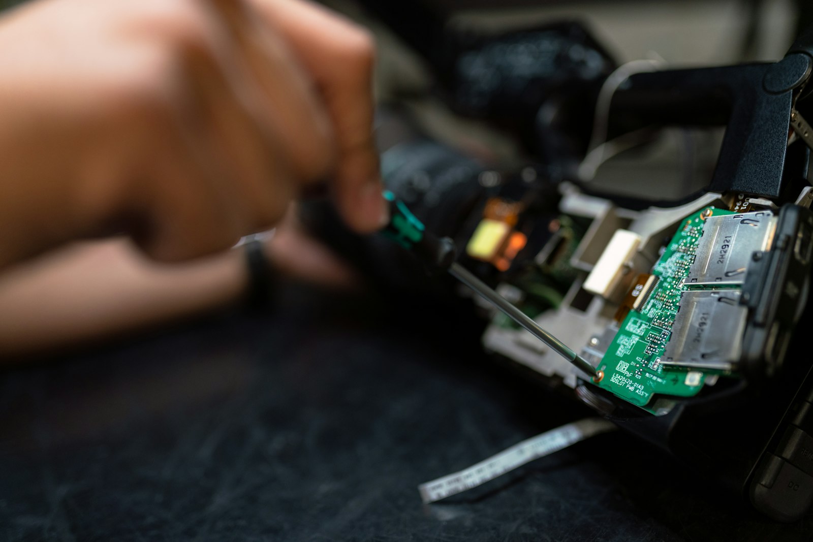 A technician working on a circuit board at the Computer Hospital repair bench